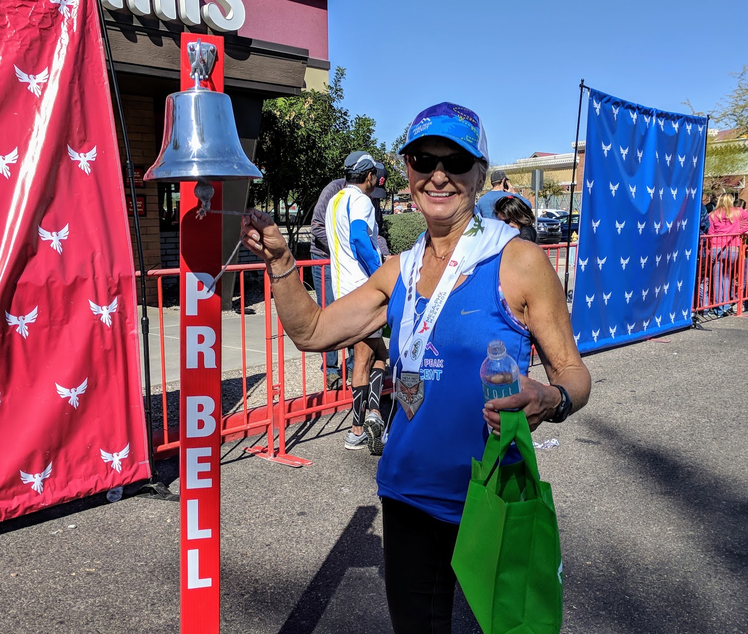 Smiling woman ringing a bell at the end of a race